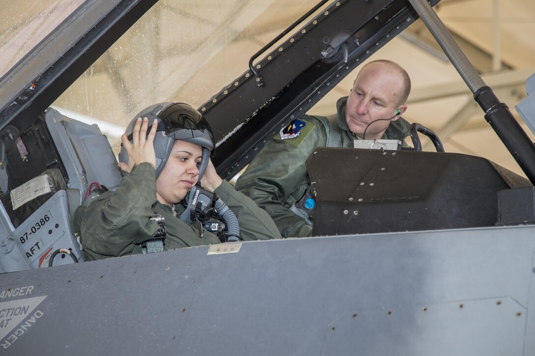 Staff Sgt. Raquel Caramanno adjusts her flight helmet while  Brig. Gen. Carl Schaefer, 412th Test Wing commander, watches before taking of in an F-16 Fighting Falcon Jan. 12. Schaefer took Caramanno on an incentive flight as an award for being named one of the U.S. Air Force's 12 Outstanding Airmen of the Year for 2016. (U.S. Air Force photo by Christopher Higgins)