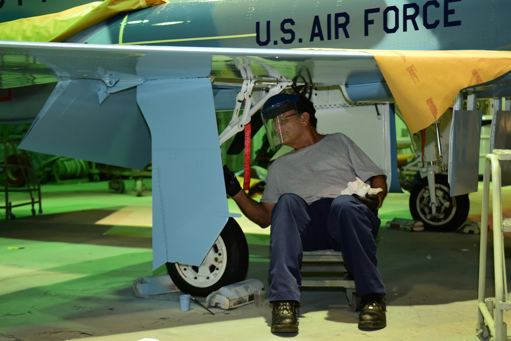 Rudy Olivarez, a Corrosion Control Specialist in the 12th Maintenance Group, applies paint to the landing gear of a T-38C Talon at Joint Base San Antonio-Randolph, Texas, Jan. 13, 2017.  Members of the corrosion control shop are changing the plane’s color scheme from two-tone gray to heritage blue, a scheme that was used by the 435th Fighter Training Squadron 40 years ago, ahead of a reunion of pilots that trained for fighter fundamentals after Jan. 1, 1977. (U.S. Air Force photo/Randy Martin) 