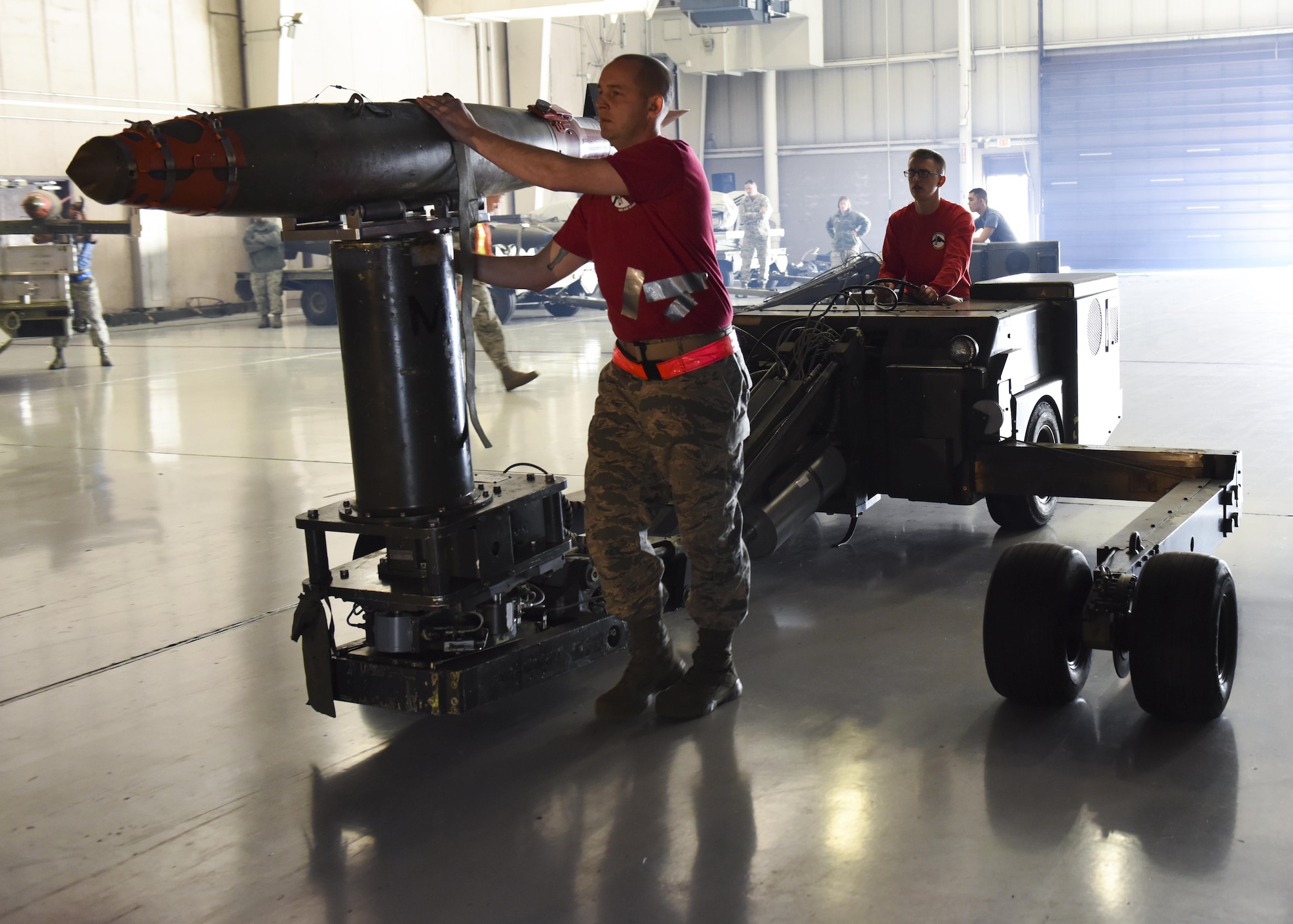 U.S. Air Force Tech. Sgt. Chase Molitor, a weapons load crew 3-member assigned to the 131st Aircraft Maintenance Squadron, left, and Airman 1st Class Zachary Frana, a weapons load crew 4-member assigned to the 393rd Aircraft Maintenance Unit, transfer a GBU-38 with a MHU-83 during the fourth quarter load competition at Whiteman Air Force Base, Mo., Jan. 6, 2017. The 3 member responsibility is to inspect all of the weapons before they get loaded and ensure
the crew has all the tools they require to complete the load.