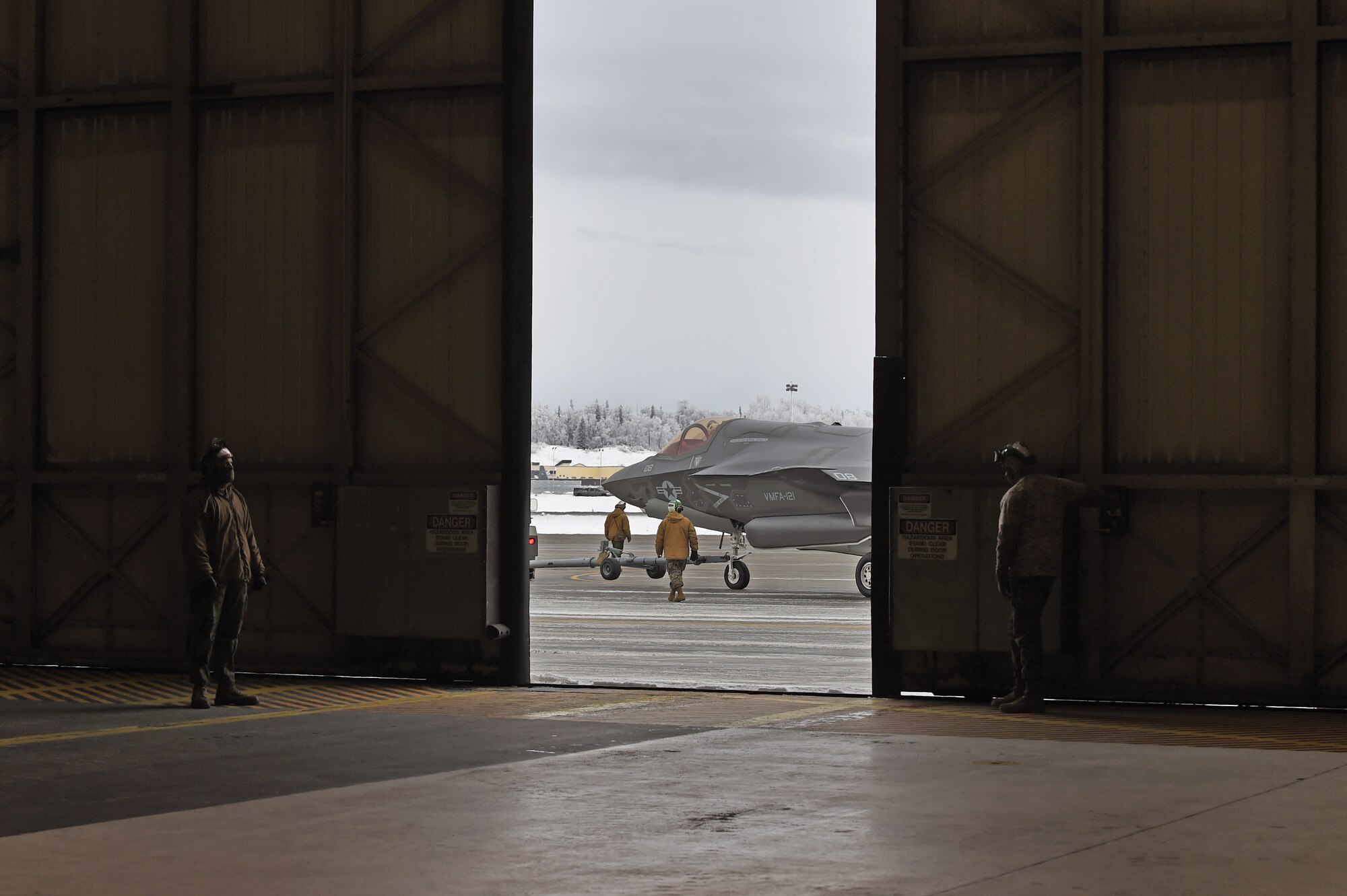 Marines assigned to Marine Fighter Attack Squadron (VMFA) 121, 3rd Marine Aircraft Wing, move F-35Bs in a hangar, Jan. 13, 2017, during a stop on Joint Base Elmendorf-Richardson, Alaska, en route to Marine Corps Air Station Iwakuni, Japan. VMFA-121 is the first operational F-35B squadron in the Marine Corps, with its relocation to 1st Marine Aircraft Wing at Iwakuni. The F-35B was developed to replace the Marine Corps’ F/A-18 Hornet, AV-8B Harrier and EA- 6B Prowler. The Short Take-off Vertical Landing (STOVL) aircraft is a true force multiplier. The unique combination of stealth, cutting-edge radar and sensor technology, and electronic warfare systems bring all of the access and lethality capabilities of a fifth-generation fighter, a modern bomber, and an adverse-weather, all-threat environment air support platform.
