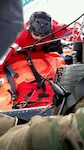 A Guardian Angel pararescueman from the 131st Rescue Squadron guides a litter carrying a civilian patient onto an HH-60G Pave Hawk helicopter during an over water rescue mission, Jan. 17, 2017. 