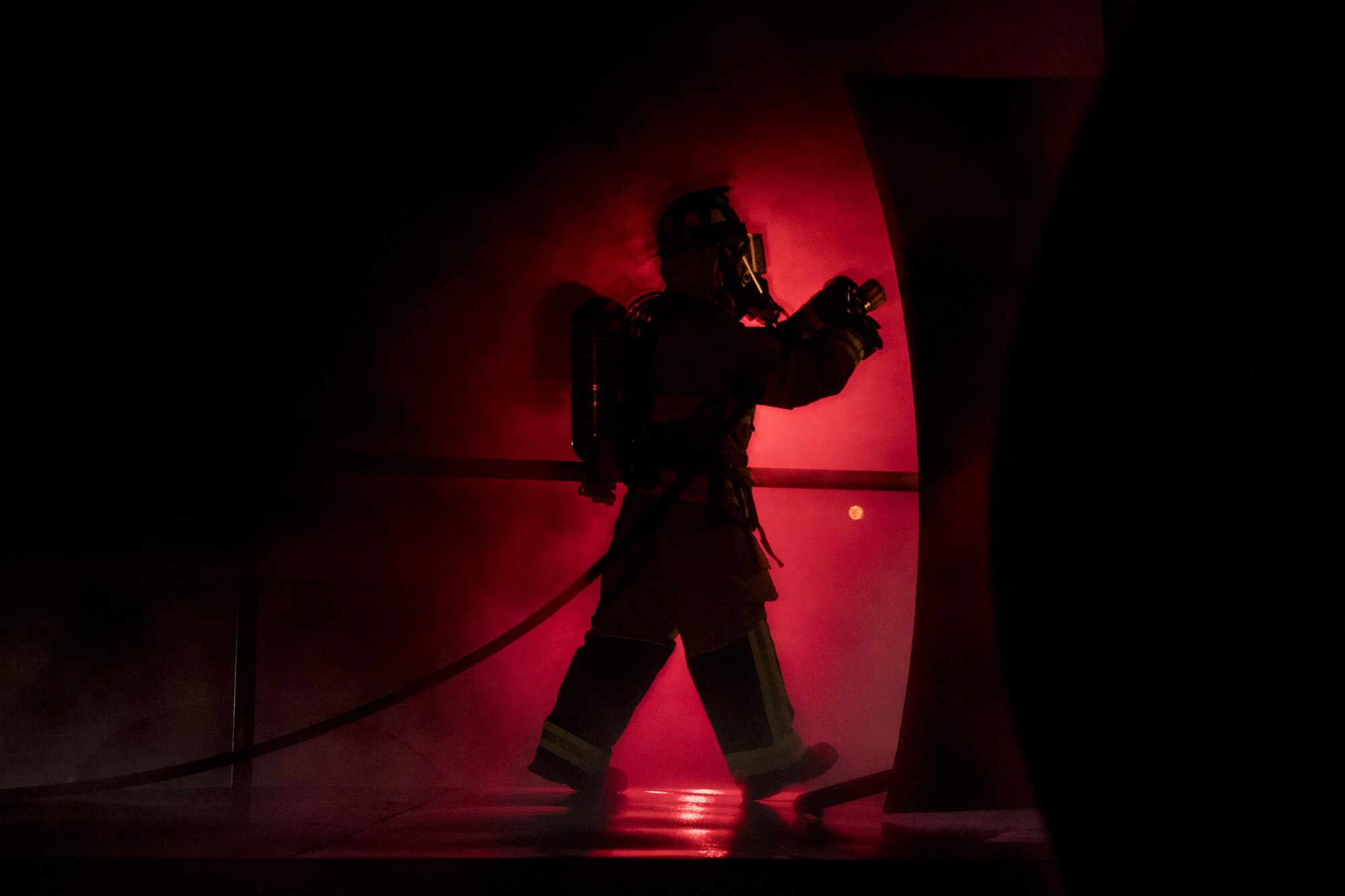 A firefighter enters a prop aircraft during nighttime, live-fire training Jan. 10, 2017, at Moody Air Force Base, Ga. After extinguishing external fires, firefighters entered the prop aircraft to continue combating the flames. (U.S. Air Force photo/Airman 1st Class Daniel Snider)