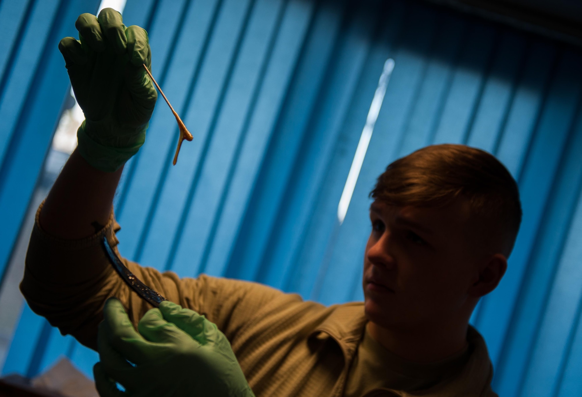 Airman 1st Class Hayden Pickett, 86th Operations Support Squadron aircrew flight equipment technician, applies adhesive to a flight helmet at Ramstein Air Base, Germany, Jan. 19, 2017. Attention to detail is key for AFE Airmen; they repair, test, and inspect all flight equipment and must ensure it is fully operational for aircrew in everyday and emergency situations. (U.S. Air Force photo by Airman 1st Class Lane T. Plummer)