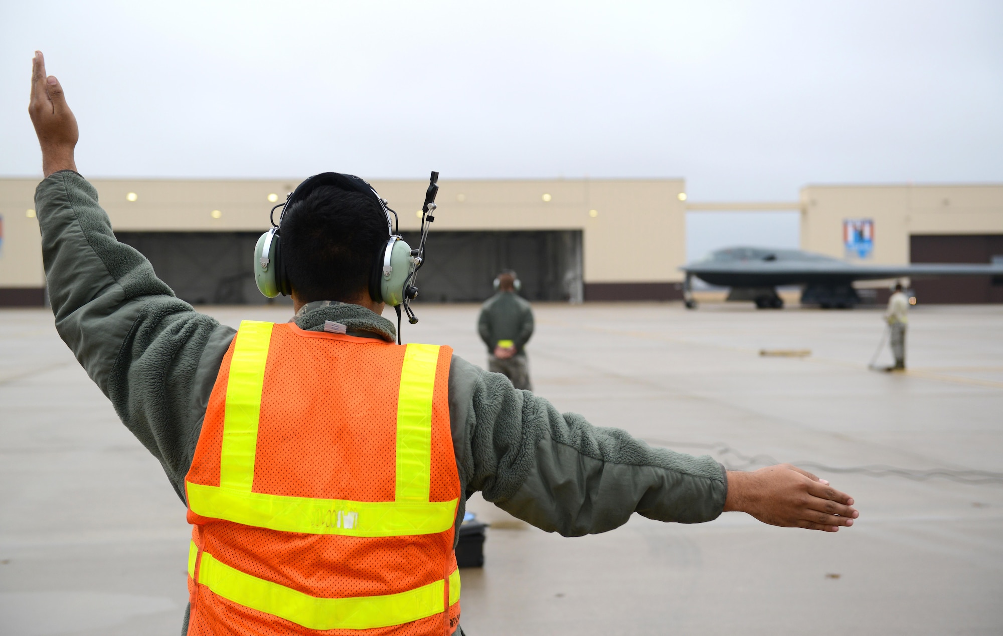 A crew chief from Whiteman Air Force Base, Mo., marshals in a B-2 Spirit stealth bomber at Whiteman Air Force Base, Mo., Jan. 19, 2017. Two B-2 Spirit stealth bombers returned after flying an approximate 30-hour sortie in support of operations near Sirte, Libya. In conjunction with the Libyan Government of National Accord, the U.S. military conducted precision airstrikes Jan. 18, 2017, destroying two Daesh camps 45 kilometers southwest of Sirte. (U.S. Air Force photo by Senior Airman Joel Pfiester)