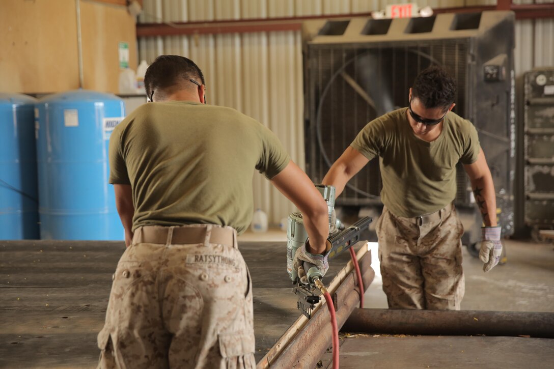 Lance Cpl. Dominic Ratsythong and Lance Cpl. Jacob Moreno, assigned through the fleet assistance program with Headquarters and Headquarters Squadron, assist with range maintenance by pre-fabricating wooden targets to support tenant and visiting commands during Weapons and Tactics Instructors course 1-17 aboard Marine Corps Air Station Yuma, Ariz., September 29, 2016.