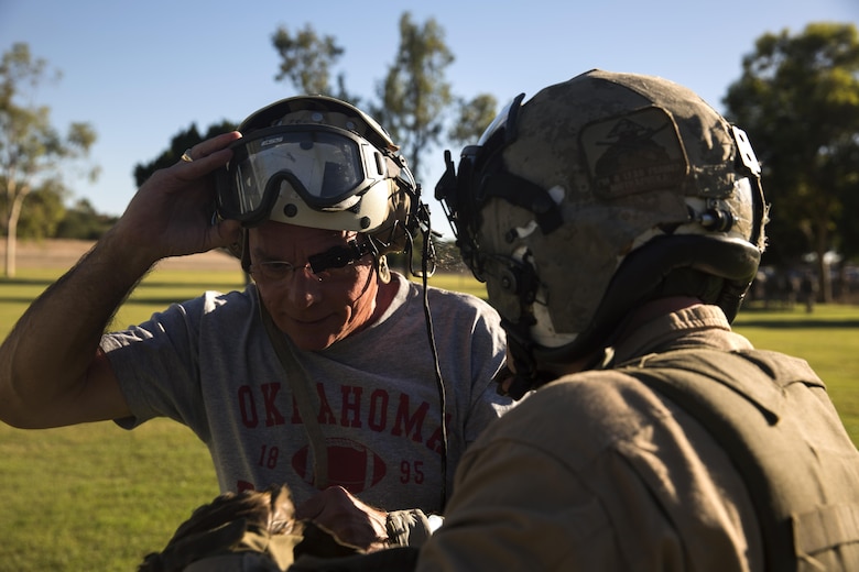 A UH-1Y crew chief with Marine Aviation Weapons and Tactics Squadron One assists an simulated displaced civilian, role-player, at Kiwanis Park in Yuma, Ariz., during a Humanitarian Assistance/Disaster Relief (HA/DR) Exercise, part of the Weapons and Tactics Instructor Course 1-17, Friday, October 14, 2016. The training exercise enabled ground, aviation and support Marines and sailors to work as a team to practice deploying medical personnel, supplies, and extract personnel and people displaced from their communities 