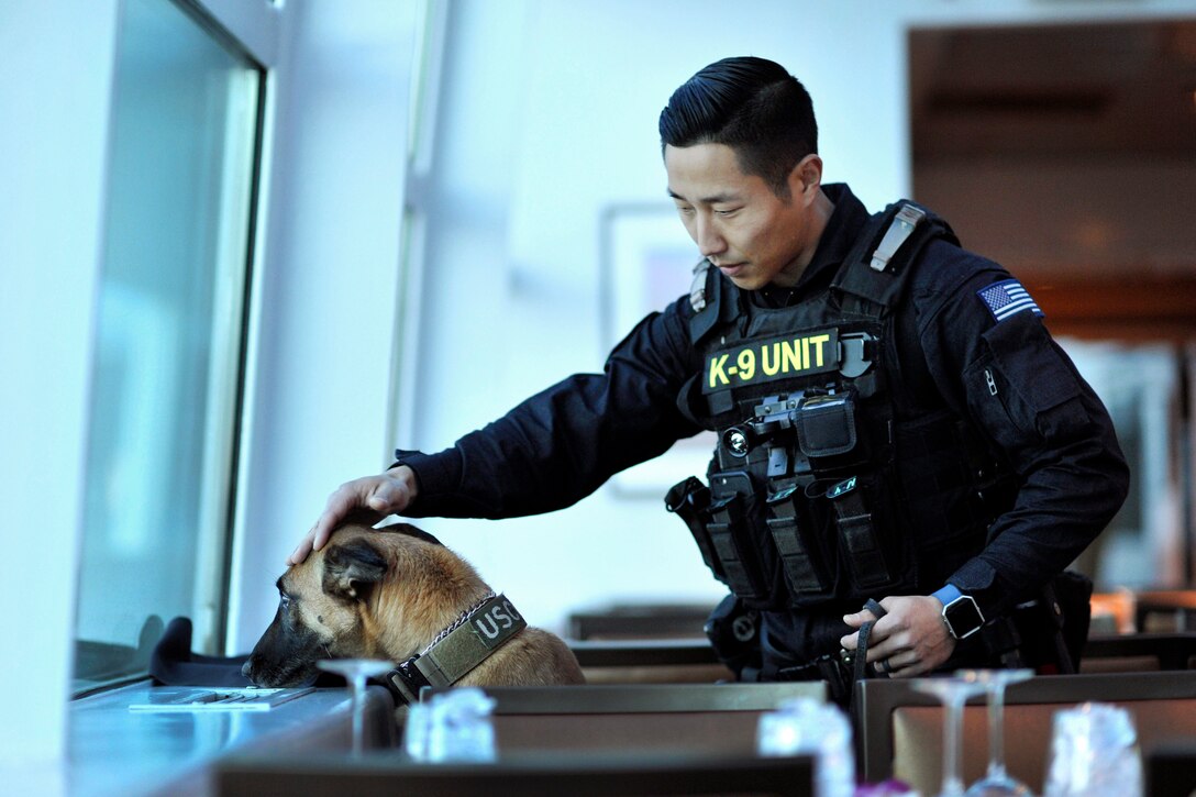 Coast Guard Petty Officer 2nd Class Richard Bacone and Ruthie, a military working dog, conduct security sweeps during a dinner cruise in Washington, D.C., Jan. 19, 2017. Coast Guard photo by Petty Officer 2nd Class Matthew S. Masaschi 