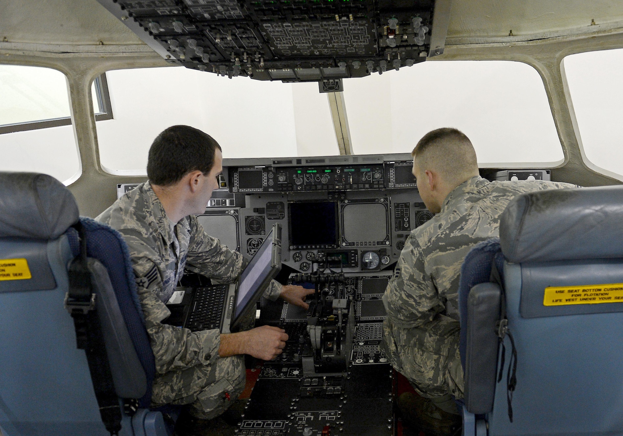 Staff Sgt. Kyle Stringer (left), 373rd Training Squadron field training detachment instructor, teaches Senior Airman Shawn Carnline, 62nd Aircraft Maintenance crew chief, about flight controls Jan. 19, 2017 at Joint Base Lewis McChord, Wash. Any maintenance personnel that work on aircraft stationed here or from other bases can come to the 373 TRS and receive advanced training. (U.S. Air Force photo/Senior Airman Divine Cox)