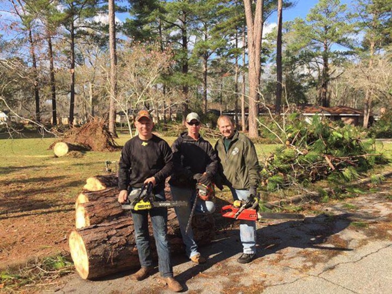 Marines pose with Darrel Ealum, a retired Marine major and current Georgia State Representative, after cutting up trees and removing debris from severe storms that swept through the city of Albany, Ga., and surrounding counties, Jan. 7.  

 
