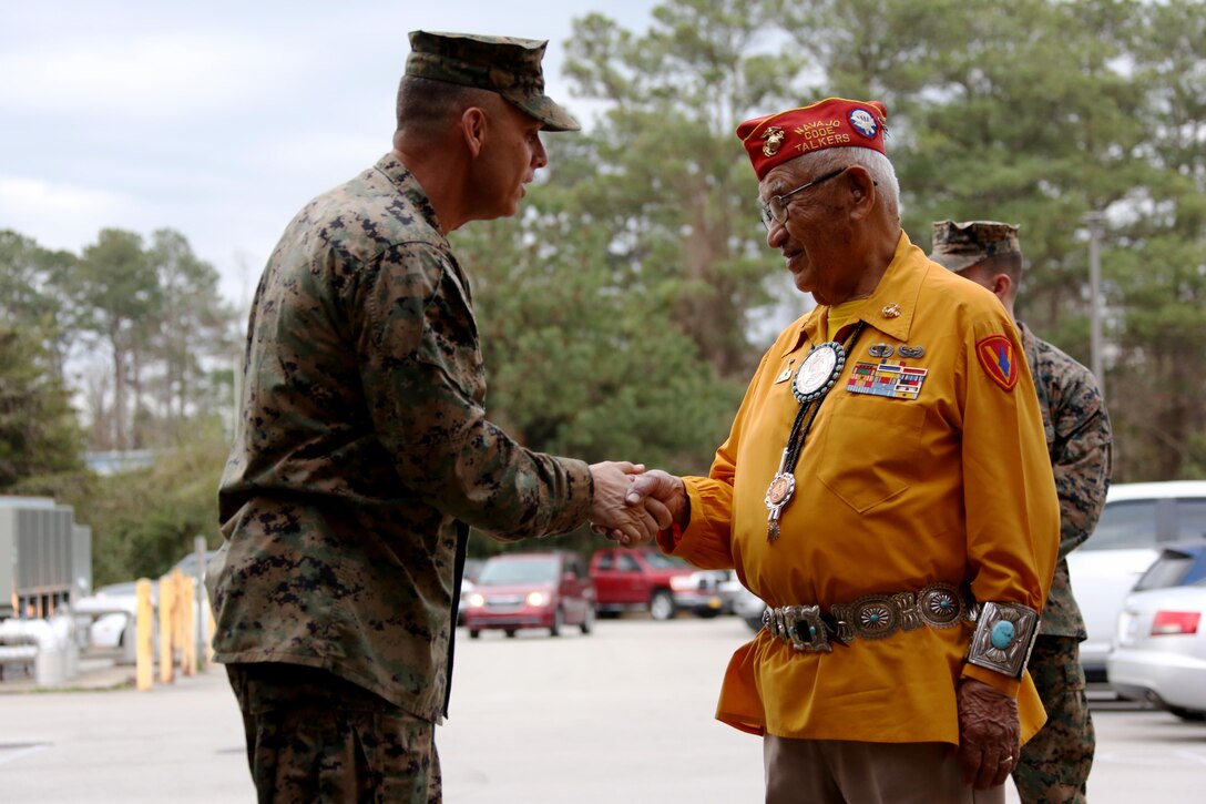 Brig. Gen. Matthew Glavy gives a challenge coin to Navajo Code Talker Thomas Begay aboard Marine Corps Air Station Cherry Point, N.C., Jan. 17, 2017. Both Glavy and Begay spoke to Marines assigned to Marine Unmanned Aerial Vehicle Squadron 2, Marine Aircraft Group 14, 2nd Marine Aircraft Wing, in regards to the past, present and future of the Marine Corps. Glavy is the 2nd MAW commanding general. (U.S. Marine Corps photo by Cpl. Jason Jimenez/ Released)