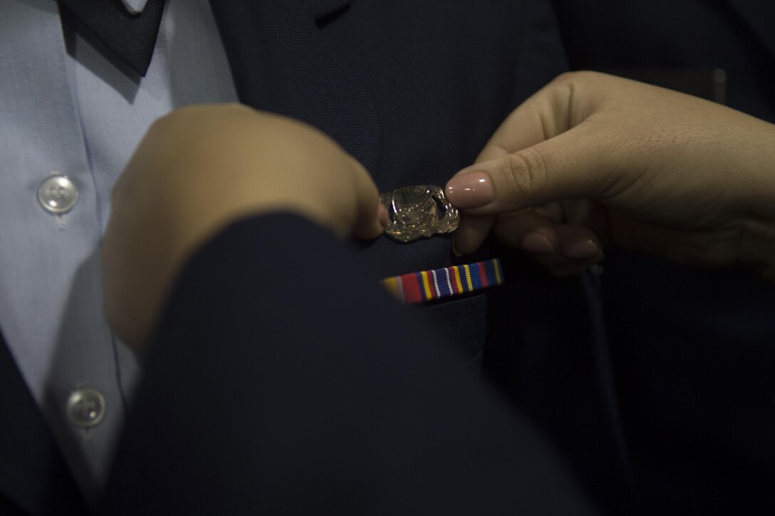 Airmen check over each other's uniforms in the early morning hours at the Base Theater on Joint Base Andrews, Md., Jan. 20, 2017, in preparation for the presidential inauguration. Approximately 200 Airmen were present to prepare themselves for their role in the inauguration. (U.S. Air Force photo by Senior Airman Mariah Haddenham)