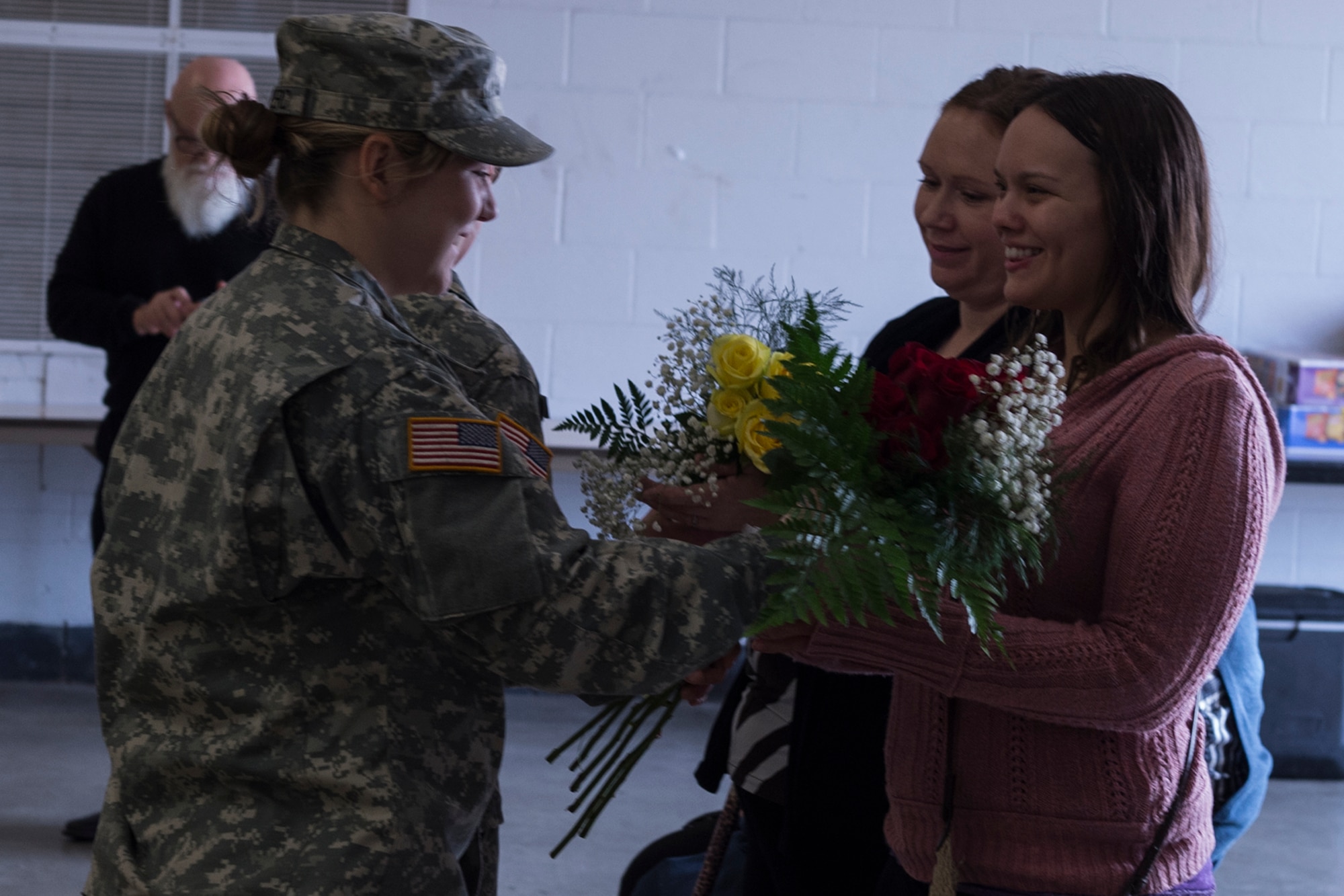 Soldiers from the 316th Psychological Operations Squadron present flowers to Eleana Laws, wife of the incoming commander, Amanda Cairney, girlfriend of the outgoing commander, during a change of command ceremony on January 21, 2017 at Grissom Air Reserve Base, Ind. The flowers were presented by the command as a token of thanks for the support offered by the two women. (U.S. Air Force photo/Staff Sgt. Dakota Bergl)