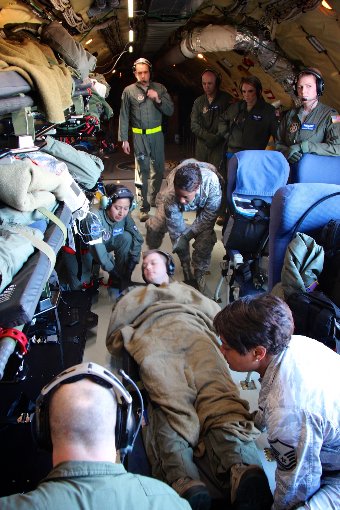 Before the sun rose, pockets of military training activity were taking place in Illinois.  Leading people with an early 0545 report time, 932nd Aeromedical Evacuation Squadron medical members, both trainees and instructors, prepare to lift a patient into a secure position before travel aboard a KC-135 aircraft.  They also explained in detail how to use the oxygen mask in case of smoke or fire to their "simulated patients" as they waited to take off on a special refueling plane, visiting from the 434th Air Refueling Wing, Grissom Air Reserve Base, Ind.   Both the 932nd Airlift Wing and 434th Air Refueling Wing, flew together to get medical training time in the air, and both are units under Air Force Reserve Command. Known as the "Gateway Wing", the 932nd Airlift Wing near Belleville, is located less than 30 minutes from the Saint Louis Arch and reservists live nationwide on both sides of the Mississippi River.  The plane took off early on January 21, 2017, Scott Air Force Base, Ill.  (U.S. Air Force photo by Lt. Col. Stan Paregien)