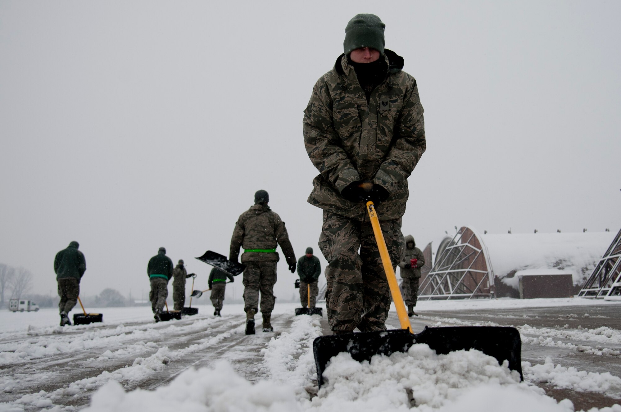 U.S. Air Force aircraft maintainers from the 25th Aircraft Maintenance Unit shovel snow in front of aircraft hangars on Osan Air Base, Republic of Korea, Jan. 20, 2017. The 25th AMU maintains the A-10 Thunderbolt IIs assigned to the 25th Fighter Squadron. (U.S. Air Force photo by Staff Sgt. Jonathan Steffen)