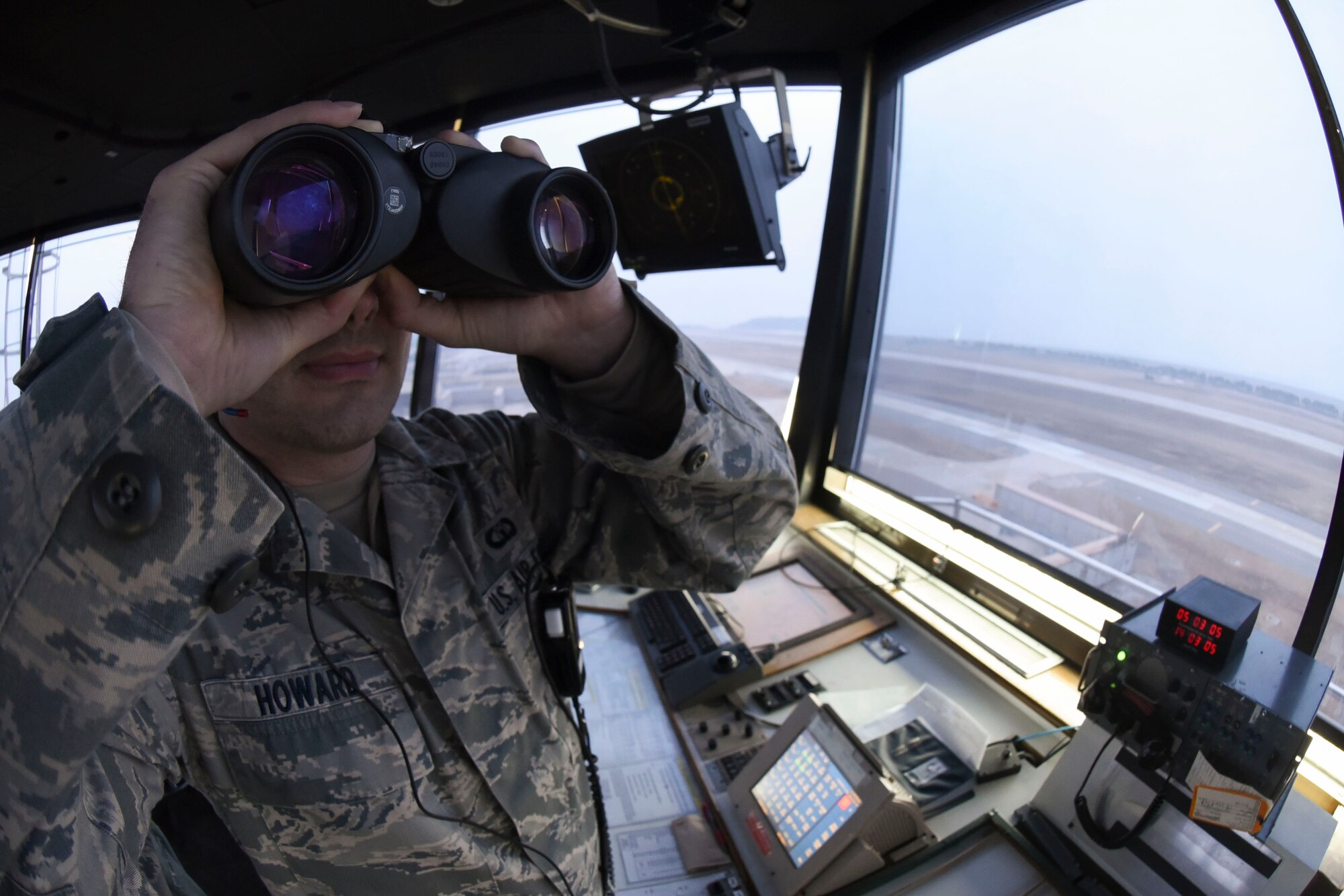 Staff Sgt. Jeffery Howard, 8th Operations Support Squadron air traffic controller, looks at the runway through his binoculars at Kunsan Air Base, Republic of Korea, Jan. 5, 2017. Howard ensures the runway is clear from any hazards to aircraft. (U.S. Air Force photo by Senior Airman Michael Hunsaker/Released)