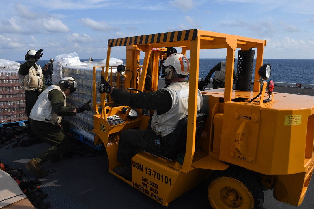 Marines load supplies onto a forklift during a vertical replenishment aboard the amphibious assault ship USS Bataan during Composite Training Unit Exercise, or Computex, in the Atlantic Ocean, Jan. 21, 2017. Navy photo by Petty Officer 2nd Class Magen F. Reed