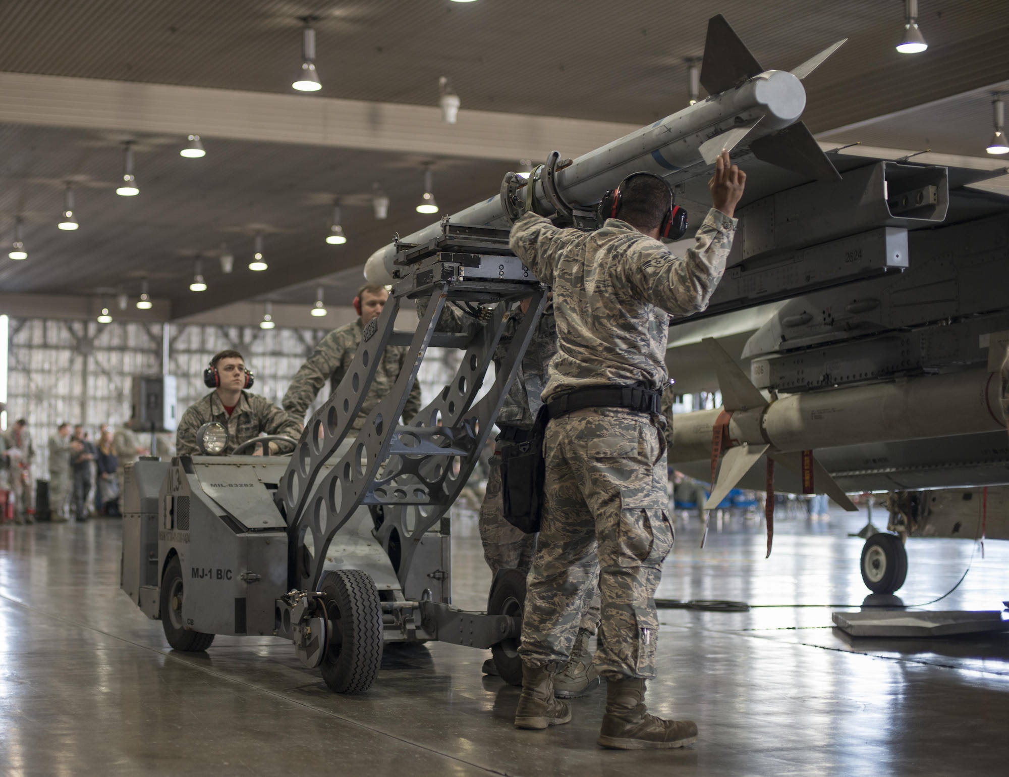 U.S. Air Force Airmen with the 13th Aircraft Maintenance Unit load crew 10, mount an AIM-120 advanced medium range air-to-air missile during the annual load crew competition at Misawa Air Base, Japan, Jan. 20, 2017. The AMRAAM missile is a versatile weapon with operational flexibility in a wide variety of scenarios, including air-to-air and surface-launch engagements. (U.S. Air Force photo by Senior Airman Brittany A. Chase)