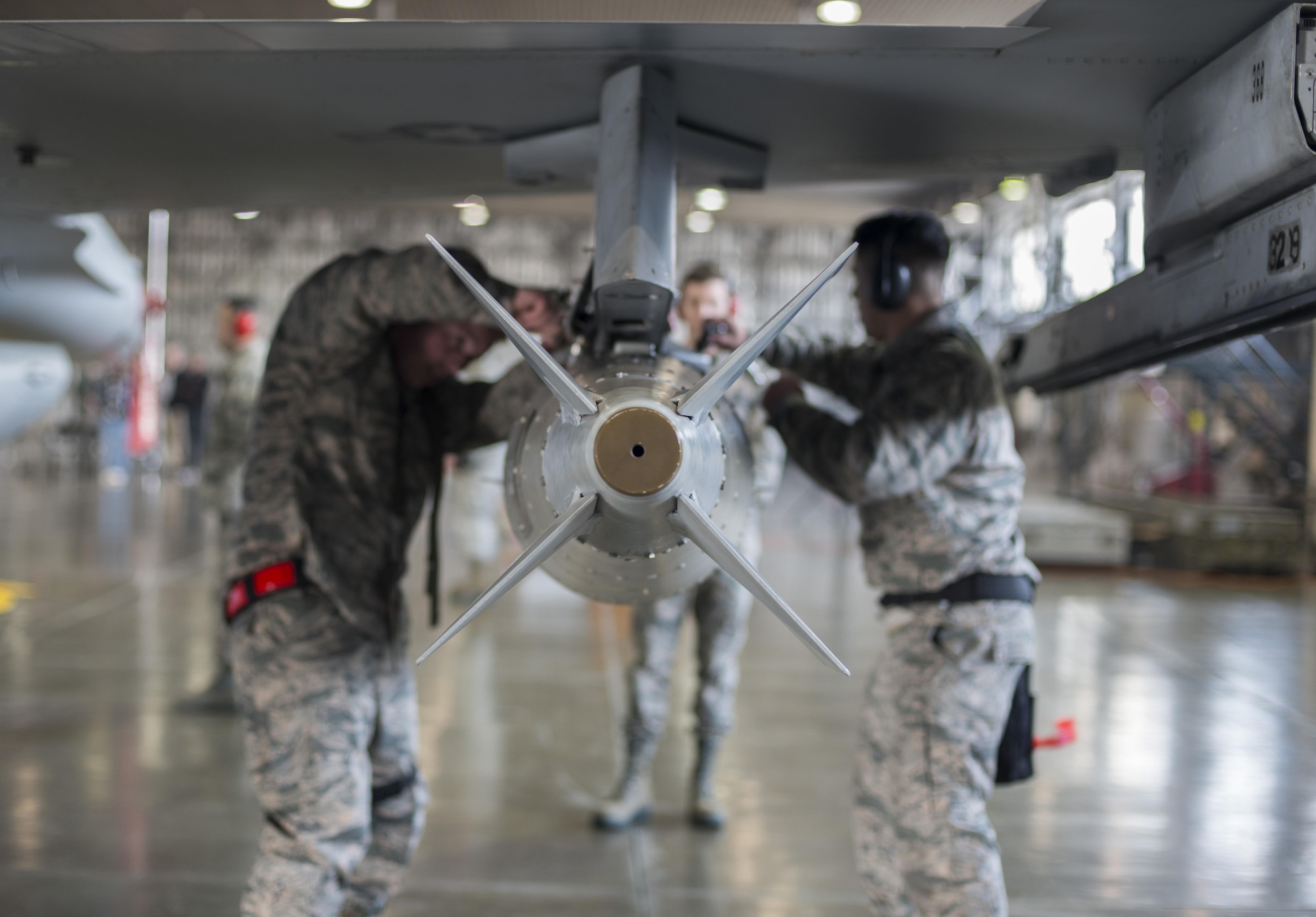 U.S. Air Force Airmen with the 13th Aircraft Maintenance Unit load crew 10, mount a Joint Direct Attack Munition GBU 31 (v) 3/B during the annual load crew competition at Misawa Air Base, Japan, Jan. 20, 2017. The JDAM is a guidance tail kit that converts existing unguided free-fall bombs into accurate, adverse weather "smart" munitions. (U.S. Air Force photo by Senior Airman Brittany A. Chase)