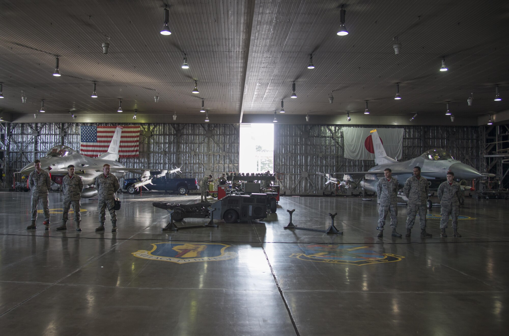 U.S. Air Force load crew 3, right, and load crew 10, members with the 13th Aircraft Maintenance Units, stand in front of two F-16 Fighting Falcons before the annual load crew competition at Misawa Air Base, Japan, Jan. 20, 2017. For the competition, the Airmen were graded on four categories: loading munitions, a written-test assessment, dress and appearance and a composite tool inspection. (U.S. Air Force photo by Senior Airman Brittany A. Chase)
