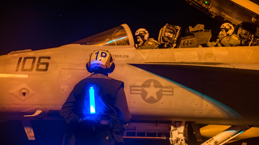 A sailor stands by to direct the crew of an F/A-18F Super Hornet aircraft on the flight deck of the aircraft carrier USS Carl Vinson in the Pacific Ocean, Jan. 14, 2017. Navy photo by Petty Officer 2nd Class Sean M. Castellano