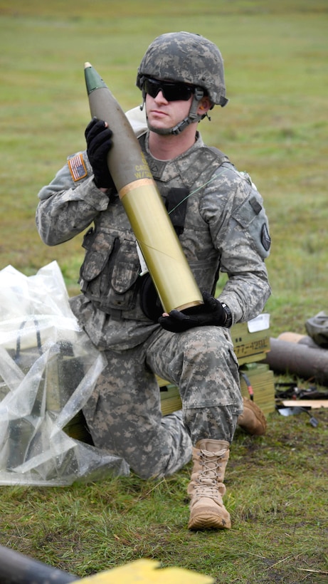 Army Pfc. Ross Murphy holds a 105mm round before test firing an M119A3 105mm howitzer system at Camp Roberts, Calif., Jan. 18, 2017. Murphy is assigned to Bravo Battery, 1st Battalion, 143rd Field Artillery Regiment. Navy photo by Petty Officer 2nd Class Timothy M. Black