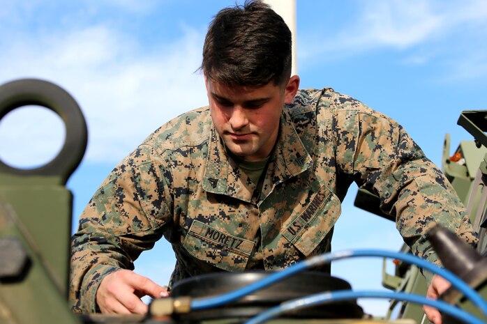 Cpl. Jimmy Moretz inspects the engine of an MK28 extended cargo truck aboard Marine Corps Air Station Cherry Point, N.C., Jan. 17, 2017. Moretz is the emergency dispatcher assigned to Marine Air Support Squadron 1, Marine Air Control Group 28, 2nd Marine Aircraft Wing, and training noncommissioned officer for his platoon in the motor and transport section of the squadron. Moretz has been recognized as the noncommissioned officer of the quarter for the period of Oct. 1, 2016 to Dec. 31, 2016 for his outstanding work in his squadron. (U.S. Marine Corps photo by Cpl. Jason Jimenez/ Released)