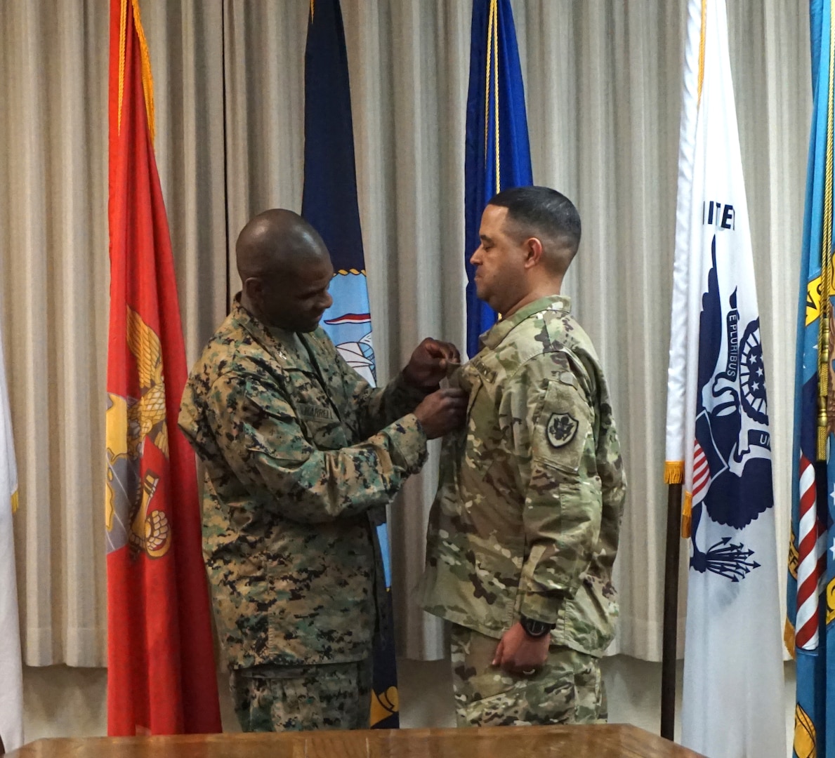 DLA Distribution San Joaquin commander Marine Col. Dre Harrell places Army Master Sgt. Scotty Mackay’s new rank insignia on his uniform during an afternoon promotion ceremony. 