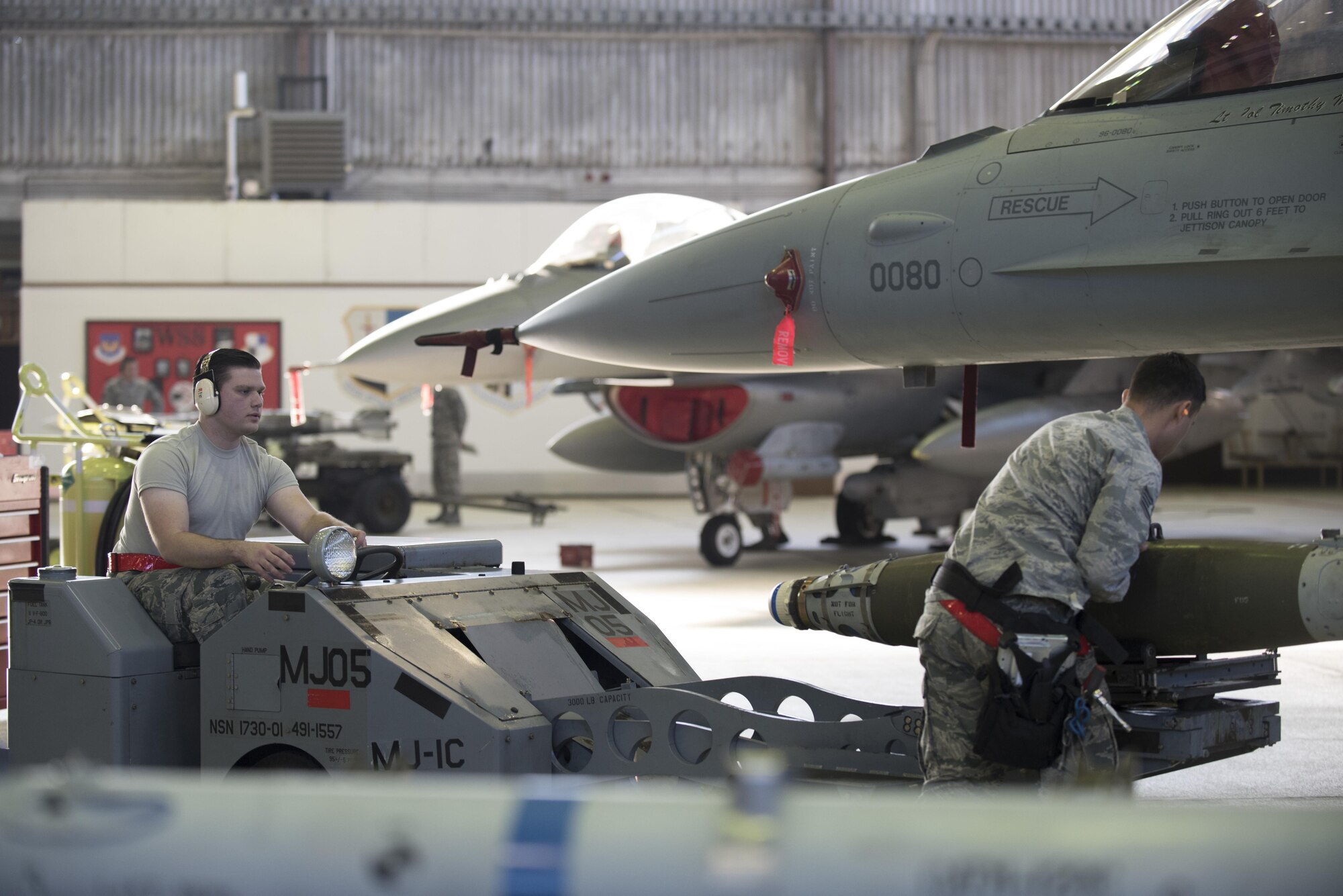 Airman 1st Class Christian Edson, 52nd Aircraft Maintenance Squadron tactical aircraft weapons system specialist, left, and Staff Sgt. Daniel Vazquez, 52nd Aircraft Maintenance Squadron weapons load crew chief, right, prepare to load an inert weapon on an F-16 Fighting Falcon during the annual weapons load competition in Hangar One at Spangdahlem Air Base, Germany, Jan. 20, 2017. The competition, consisting of two competing teams, was scored for safety and reliability, but speed and technical accuracy played a major role in scoring points. Winners from the competition will be announced at the Maintenance Professional of the Year banquet March 10, 2017. (U.S. Air Force photo by Airman 1st Class Preston Cherry)