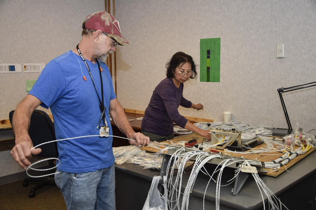 Trey Wilson and Nhan Le, 564th Aircraft Maintenance Squadron Block 45 avionic technicians, work together to route wire strands while building an integrated flight management system kit for the KC-135 Stratotanker aircraft in building 986 Nov. 15, 2016, Tinker Air Force Base, Oklahoma. The desktop shop aids shown here were custom built by the 564th AMXS to allow work that used to be done on the aircraft to now be done in the shop for more reliability, consistency and quicker final installation. (U.S. Air Force photo/Greg L. Davis)