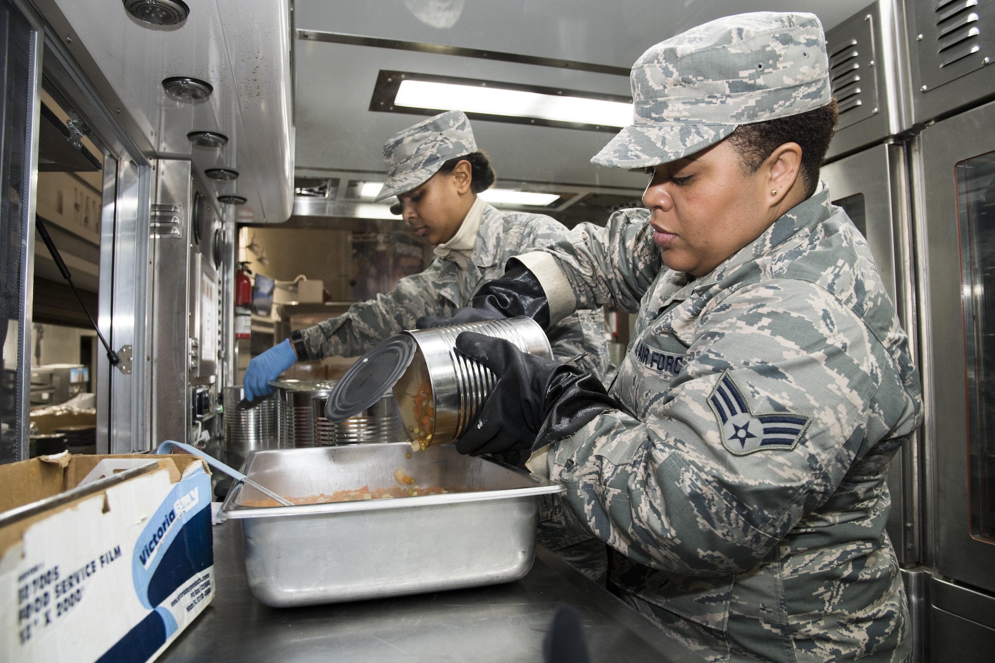 U.S. Air Force Senior Airman Kandaace Kirk, from the 116th Air Control Wing (ACW) Services Flight, Georgia Air National Guard (ANG), pours a can of mixed vegetables in a pan while preparing dinner for joint-forces personnel supporting the 58th Presidential Inauguration, Washington, D.C., January 19, 2017. A team of 10 Airmen from the 116th ACW deployed with their Disaster Relief Mobile Kitchen Trailer, or DRMKT.  Working from FedEx Field, home to the Washington Redskins, the team worked along side services teams from other ANG units across the nation preparing and serving meals to about 3,500 joint-force members per day deployed to the National Capital Region. In all, about 7,500 National Guard Soldiers and Airmen, from 44 states, three territories and the District of Columbia, served with the specially created Joint Task Force – District of Columbia. As a whole, National Guard Soldiers and Airmen augmented the U.S. Secret Service, U.S. Capitol Police and D.C. Metropolitan Police forces on a range of support including traffic control, crowd management, logistics and communication. (U.S. Air National Guard photo by Senior Master Sgt. Roger Parsons)