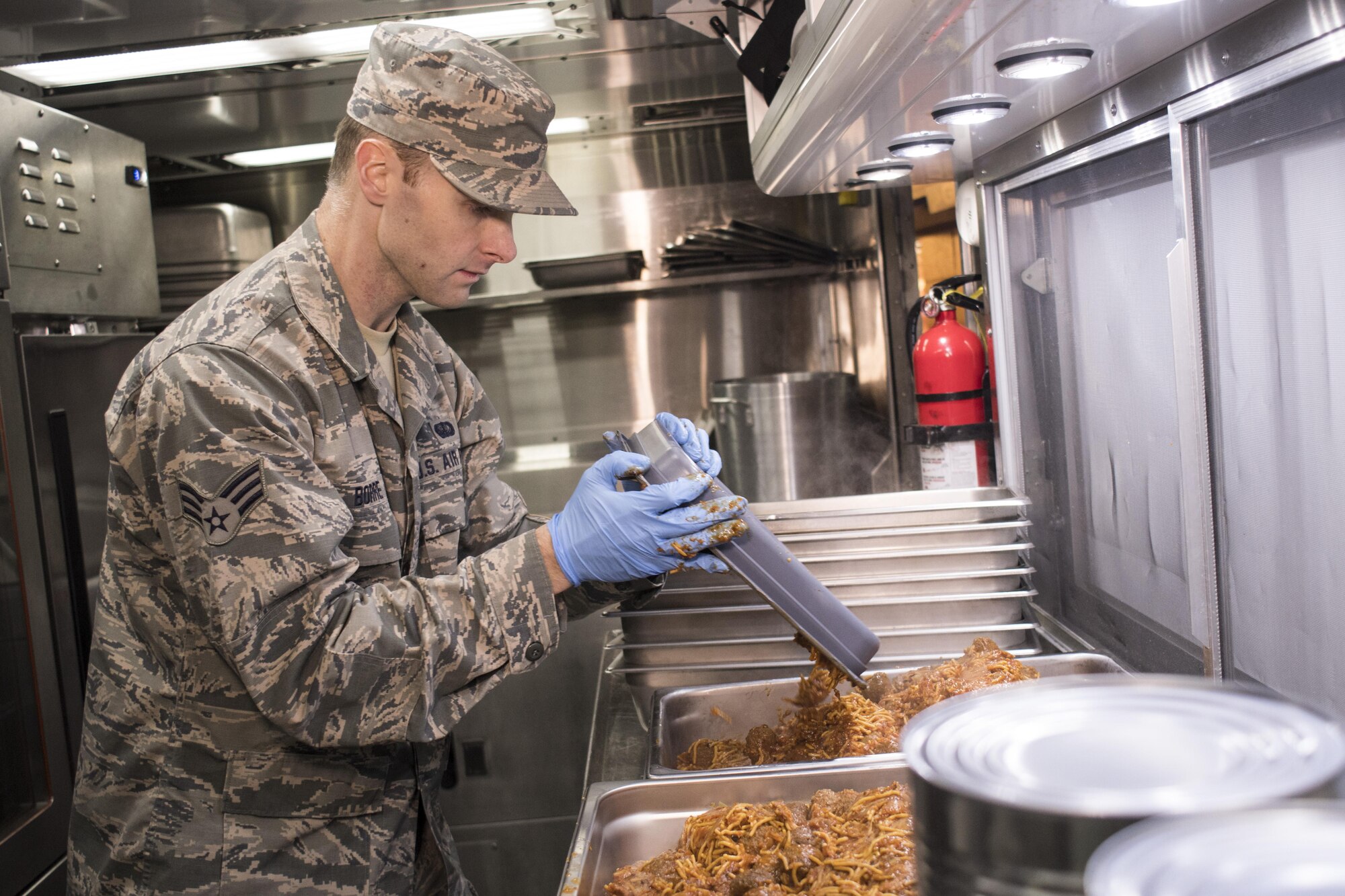 U.S. Air Force Senior Airman Charles Borre from the 116th Air Control Wing (ACW) Services Flight, Georgia Air National Guard (ANG), prepares a tray of spaghetti during dinner preparation for joint-forces personnel supporting the 58th Presidential Inauguration, Washington, D.C., January 18, 2017. A team of 10 Airmen from the 116th ACW deployed with their Disaster Relief Mobile Kitchen Trailer (DRMKT).  Working from FedEx Field, home to the Washington Redskins, the team worked along side services teams from other ANG units across the nation preparing and serving meals to about 3,500 joint-force members per day deployed to the National Capital Region. In all, about 7,500 National Guard Soldiers and Airmen, from 44 states, three territories and the District of Columbia, served with the specially created Joint Task Force – District of Columbia. As a whole, National Guard Soldiers and Airmen augmented the U.S. Secret Service, U.S. Capitol Police and D.C. Metropolitan Police forces on a range of support including traffic control, crowd management, logistics and communication. (U.S. Air National Guard photo by Senior Master Sgt. Roger Parsons)