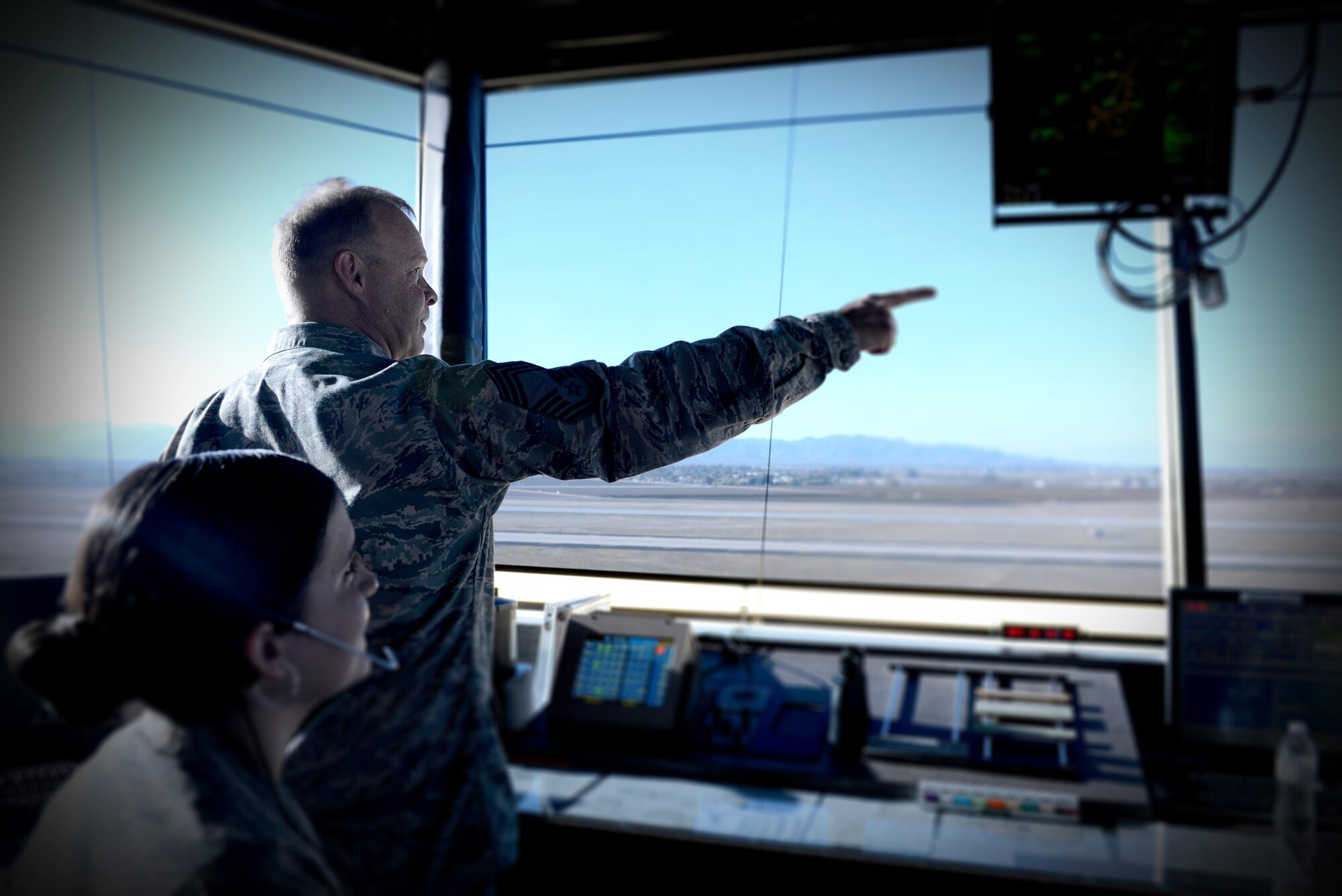 Airman 1st Class Natalie Lamia, 56th Operations Support Squadron air traffic controller, monitors Chief Master Sgt. Tadd Cahow, 56th OSS superintendent, as he issues his final clearance Jan. 5, 2017 at Luke Air Force Base, Ariz. After nearly 30 years of service, Chief Master Sgt. Cahow passed the torch to the next generation of Airmen.