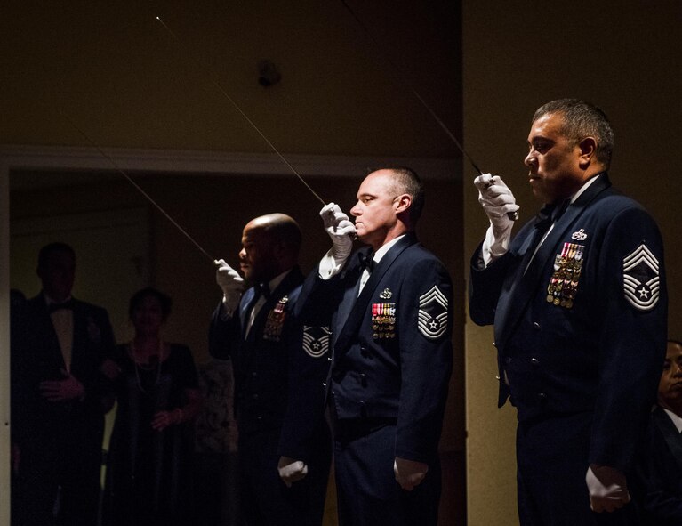 A cordon of chief master sergeants stand ready to raise their sabers while one of the base’s newest chiefs waits to enter the room during a recognition ceremony Jan. 20 at Eglin Air Force Base, Fla.  Six new chiefs were recognized during the formal ceremony and dinner.  (U.S. Air Force photo/Samuel King Jr.)