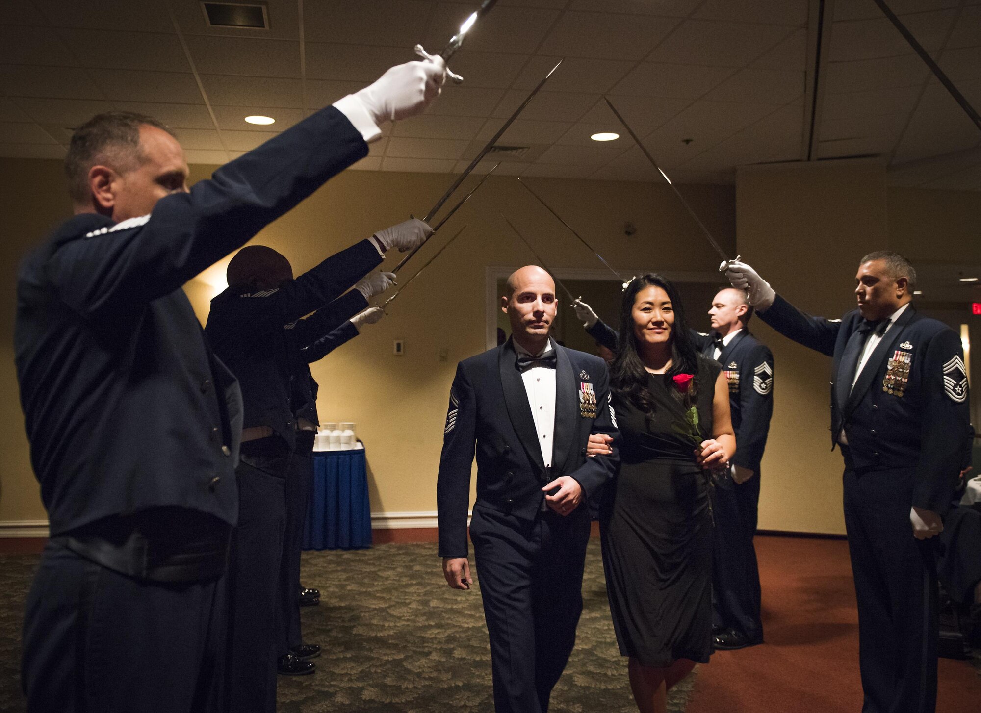 Senior Master Sgt. Mark Duarte, 359th Training Squadron, and his spouse walk beneath the saber cordon at the beginning of the recognition ceremony Jan. 20 at Eglin Air Force Base, Fla.  Six new chiefs were recognized during the formal ceremony and dinner.  (U.S. Air Force photo/Samuel King Jr.)
