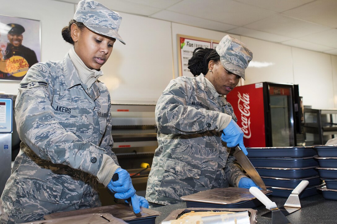 Air Force Airmen 1st Class Kayla Akers, left, and Ambrasia Washington prepare cakes during dinner preparation for joint forces personnel supporting the 58th presidential inauguration in Washington, Jan. 18, 2017. Akers and Washington are culinary arts specialists assigned to the Georgia Air National Guard’s 116th Air Control Wing Services Flight. Air National Guard photo by Senior Master Sgt. Roger Parsons