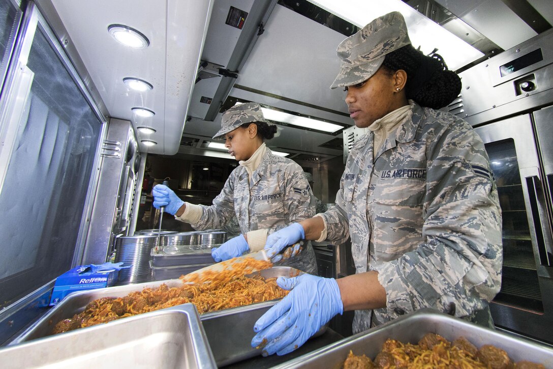 Air Force Airmen 1st Class Ambrasia Washington, right, and Kayla Akers prepare trays of spaghetti and meatballs during dinner preparation for joint forces personnel supporting the 58th presidential inauguration in Washington, Jan. 18, 2017. Washington and Akers are culinary arts specialist assigned to the Georgia Air National Guard’s 116th Air Control Wing Services Flight. Air National Guard photo by Senior Master Sgt. Roger Parsons