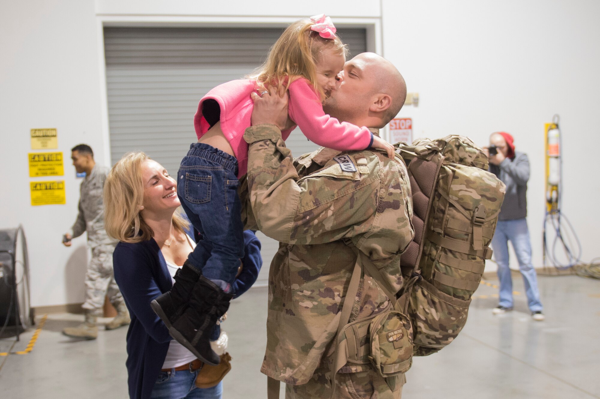 Capt. Jacob Becker, 921st Contingency Response Squadron airfield operations officer, hugs and kiss his daughter as he returns from a three-month deployment to Iraq, in support of Operation Inherent Resolve, Jan. 14, 2017, at Travis Air Force Base, California.  The CRW played a crucial role in reopening Qayyarah West Airfield and moving more than 1,423 short tons of cargo in and out of the region. (U.S. Air Force Photo by Tech. Sgt. Liliana Moreno)