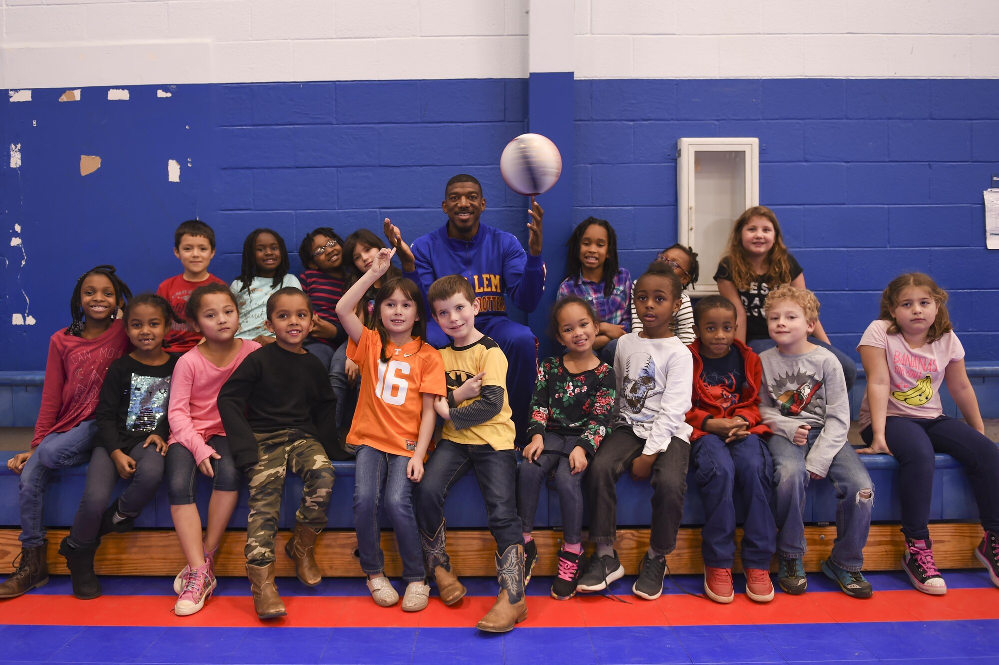 Anthony “Buckets” Blakes, a Harlem Globetrotters point guard, performs a basketball trick with a group of military children Jan. 20, 2017, at the Little Rock Air Force Base Youth Center, Ark. In March 2016, Buckets made the highest shot in team history. From approximately 300 ft. above Georgia’s Stone Mountain, he connected with a shot to a basketball hoop located below. (U.S. Air Force photo by Senior Airman Harry Brexel) 