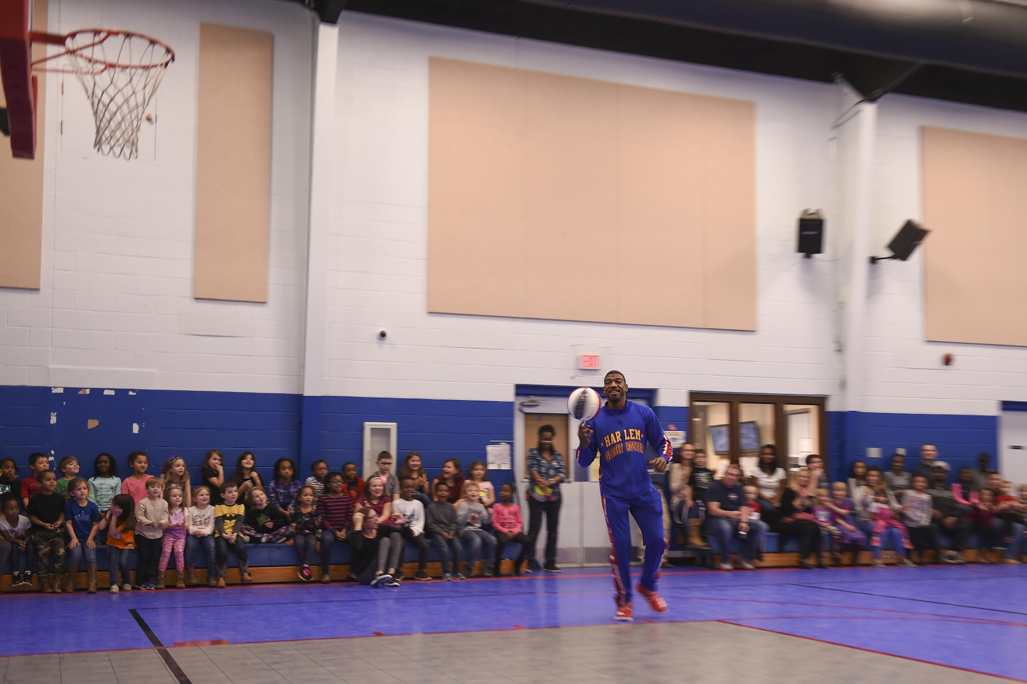 Anthony “Buckets” Blakes, a Harlem Globetrotters point guard, showcases a basketball trick to a group of military families, Jan. 20, 2017, at the Little Rock Air Force Base Youth Center, Ark. Buckets routinely works with and mentors children, as a Harlem Globetrotter Ambassador of Goodwill. (U.S. Air Force photo by Senior Airman Harry Brexel)