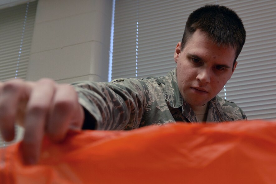 U.S. Air Force Airman 1st Class Nicholas Fournier, 20th Operation Support Squadron aircrew flight equipment apprentice, inspects a parachute for tears at Shaw Air Force Base, S.C., Jan. 23, 2017. The 20th OSS AFE Airmen spend four to eight hours performing an annual inspection of a single parachute, checking for serviceability to keep 20th Fighter Wing pilots safe in the event of an emergency. (U.S. Air Force photo by Airman 1st Class Destinee Sweeney)