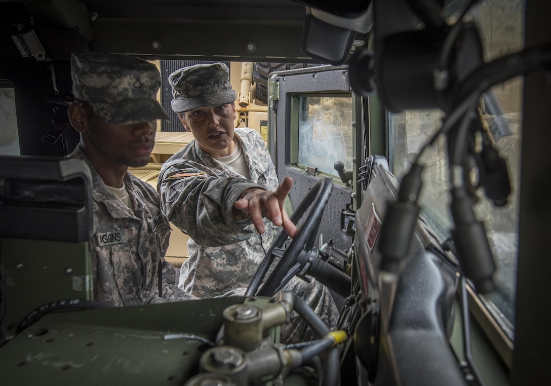 U.S. Army Reserve Sgt. Christina Wallace of Blairsville, Ga., teaches Humvee preventative maintenance checks and services to Pvt. 1st Class Keithley Huggins, an information technology specialist from Brooklyn, N.Y., in the 335th Signal Command (Theater) motor pool in East Point, Ga., Jan. 22, 2017. 