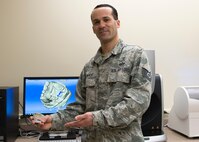 Tech. Sgt. Manuel Painter holds up a 3D printed dental mold in front of his workstation Dec. 14, 2016, Fairchild Air Force Base, Wash. The dental laboratory is equipped to create, modify and refine dental prostheses from scratch, using advanced scanners and 3D models.