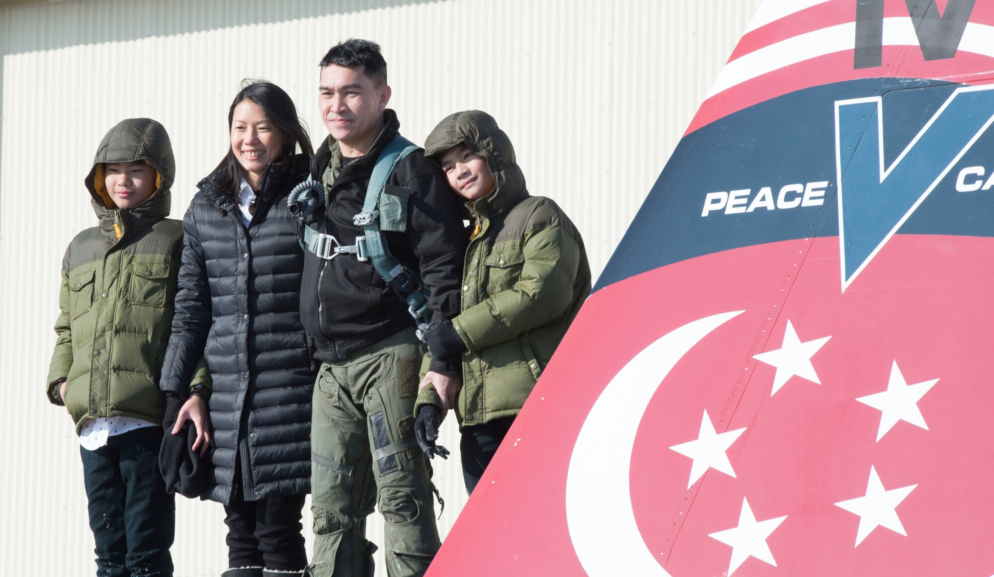 Republic of Singapore Air Force Senior Lieutenant Colonel Tham Yeow Min, 428th Fighter Squadron senior-ranking officer, poses with his family on the 428th flagship, Jan. 17, 2017, at Mountain Home Air Force Base, Idaho. Tham handed command over to Lieutenant Colonel Oon Kok Choon at the Peace Carvin V change of assignment and appointment parade. (U.S. Air Force photo by Senior Airman Malissa Lott/Released)
