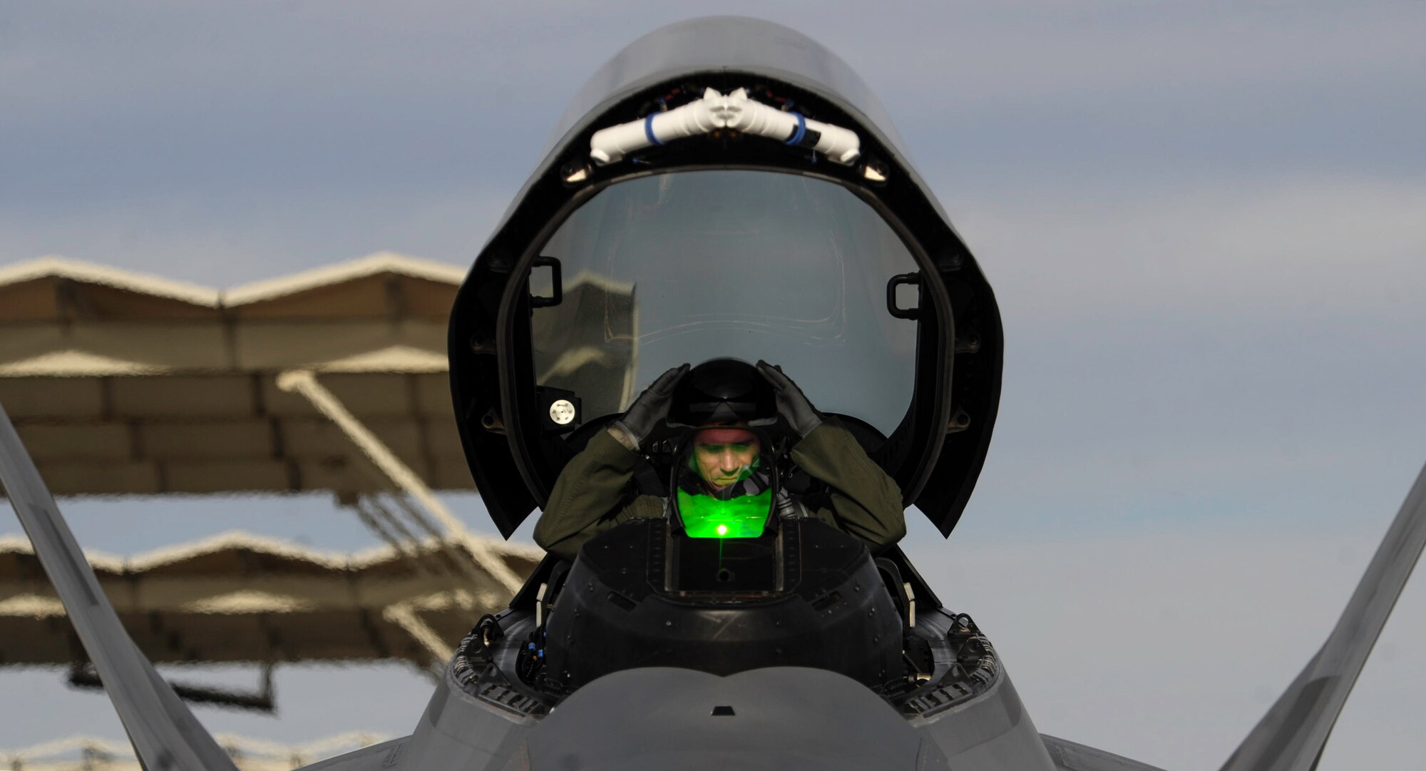 An F-22 Raptor pilot assigned to the 1st Fighter Wing, Joint Base Langley-Eustis, Va., removes his helmet after landing on Nellis Air Force Base, Nev., Jan. 18, 2017. Red Flag missions are conducted on the 2.9 million acres of the Nevada Test and Training Range with 1,900 possible targets, realistic threat systems and opposing enemy forces. (U.S. Air Force photo by Airman 1st Class Kevin Tanenbaum/Released)