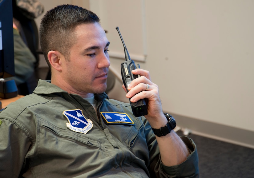 Lt. Col. David Fink, 11th Wing command post director, receives a status update through his walkie-talkie at Joint Base Andrews, Md., Jan. 20, 2017, about Airmen participating in the 58th Presidential Inauguration parade in the District of Columbia. As director, Fink coordinated between the command post and the crisis action team to ensure the proper dissemination of information affecting base entities and Air Force personnel during the historic event. (U.S. Air Force photo by Staff Sgt. Joe Yanik)
