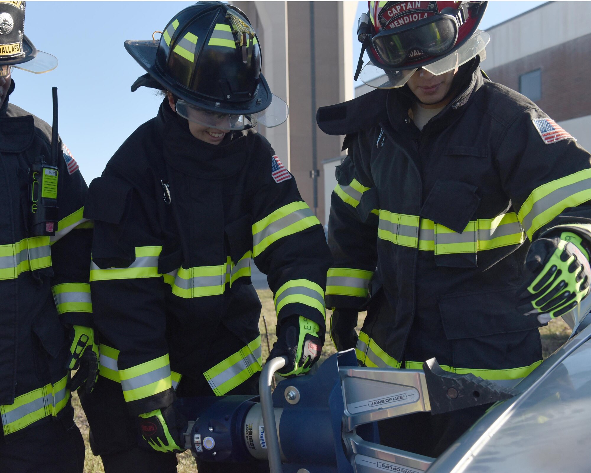 U.S. Air Force Airman 1st Class Casarah Pine, 325th Force Support Squadron food services specialist, receives instruction on how to properly use a vehicle extrication tool at Tyndall Air Force Base, Fla., Dec. 7, 2016. The Air Force Specialty immersion program provides Tyndall Airmen with the opportunity to experience another career field before officially applying for retraining into the chosen career field. (U.S. Air Force photo by Airman 1st Class Cody R. Miller/Released)