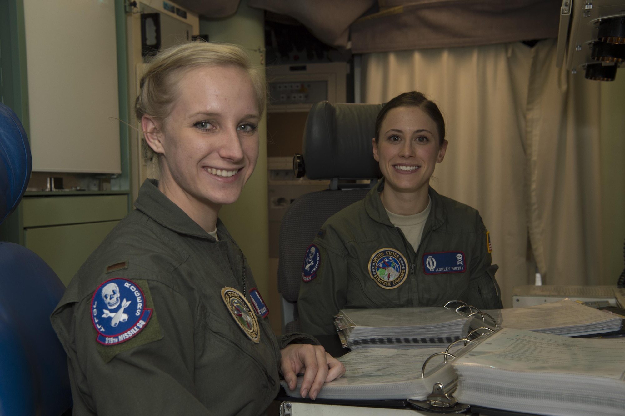 First Lt. Ashley Mirsky, 319th Missile Squadron missile combat crew commander, and 2nd Lt. Marie Blair, 319th MS deputy missile combat crew commander, pose for a photo in a launch control center in the 90th Missile Wing missile complex, Dec. 19, 2016. They have established an effective team dynamic by focusing on the positive attributes each brings to their partnership. (U.S. Air Force photo by 1st Lt. Veronica Perez)
