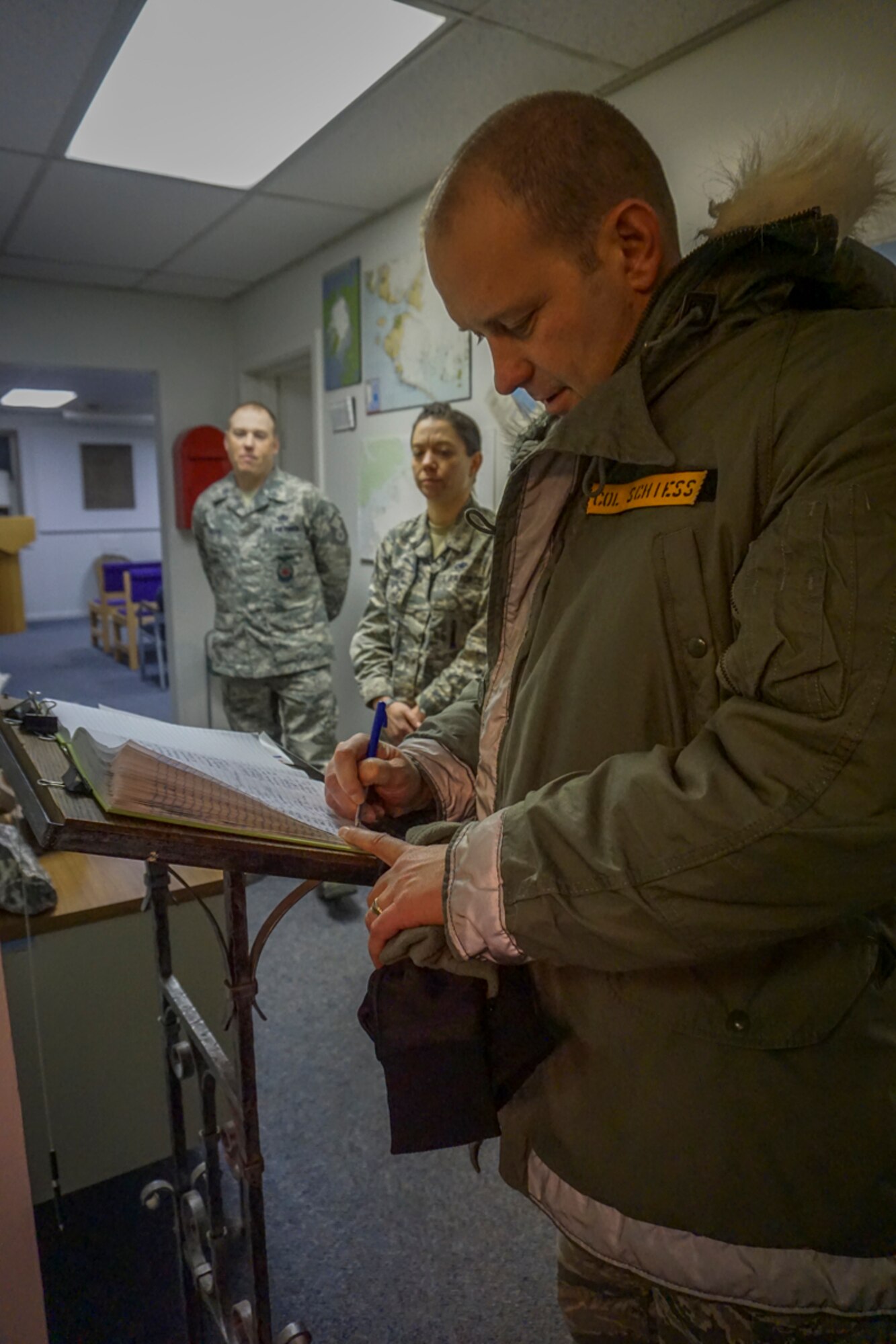THULE AIR BASE, Greenland – Col. Doug Schiess, 21st Space Wing commander, signs the guest log at Thule Air Base, Greenland, Jan. 12, 2017. Schiess visited with the 821st Air Base Group and the 12th Space Warning Squadron to see how well the mission partners from Greenland, Denmark and Canada work together. (Courtesy photo)