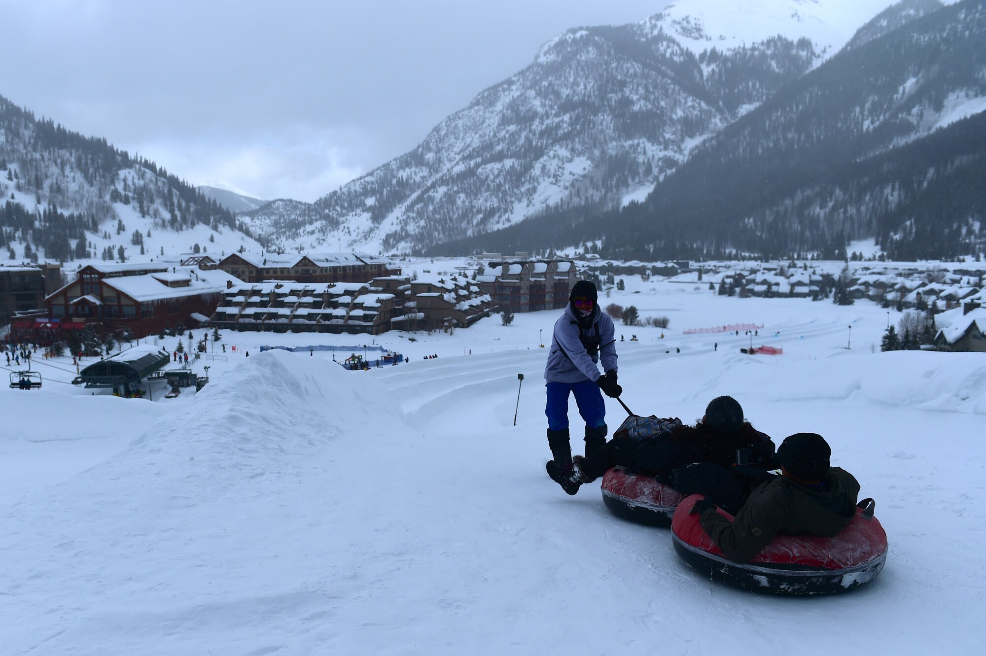A Copper Mountain employee propels SnoFest attendees down a tubing hill Jan. 21, 2017, at Copper Mountain, Colo. SnoFest is a military appreciation event hosted by the Front Range military bases including discount lift tickets, lodging and family activities. (U.S. Air Force photo by Airman Jacob Deatherage/Released)