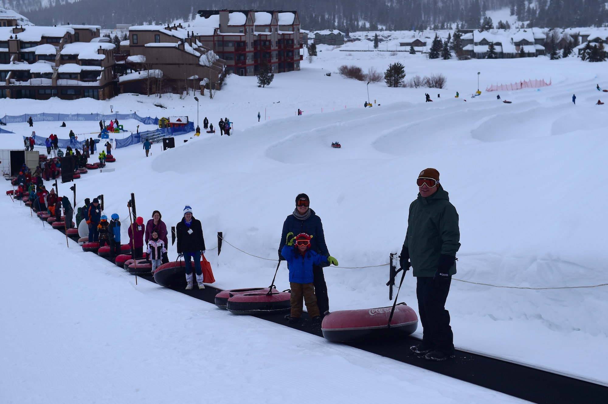 SnoFest attendees ride a conveyer belt to the top of the tubing hill Jan. 21, 2017, at Copper Mountain, Colo. SnoFest included family events such as a tubing hill, a cardboard sled derby and a buffet dinner. (U.S. Air Force photo by Airman Jacob Deatherage/Released)